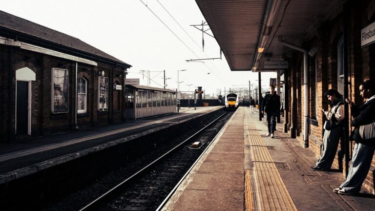 Commuters on a railway platform as a train arrives