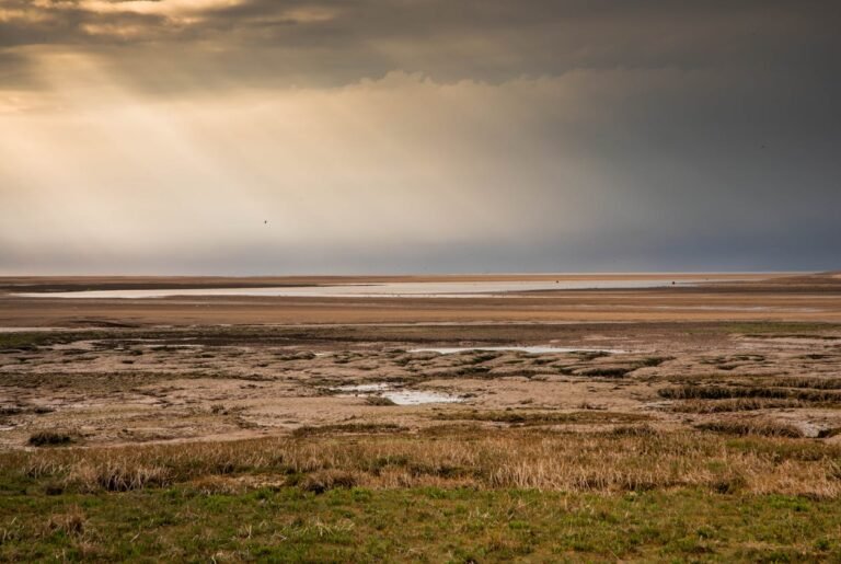 Norfolk beach with sunlight breaking through clouds